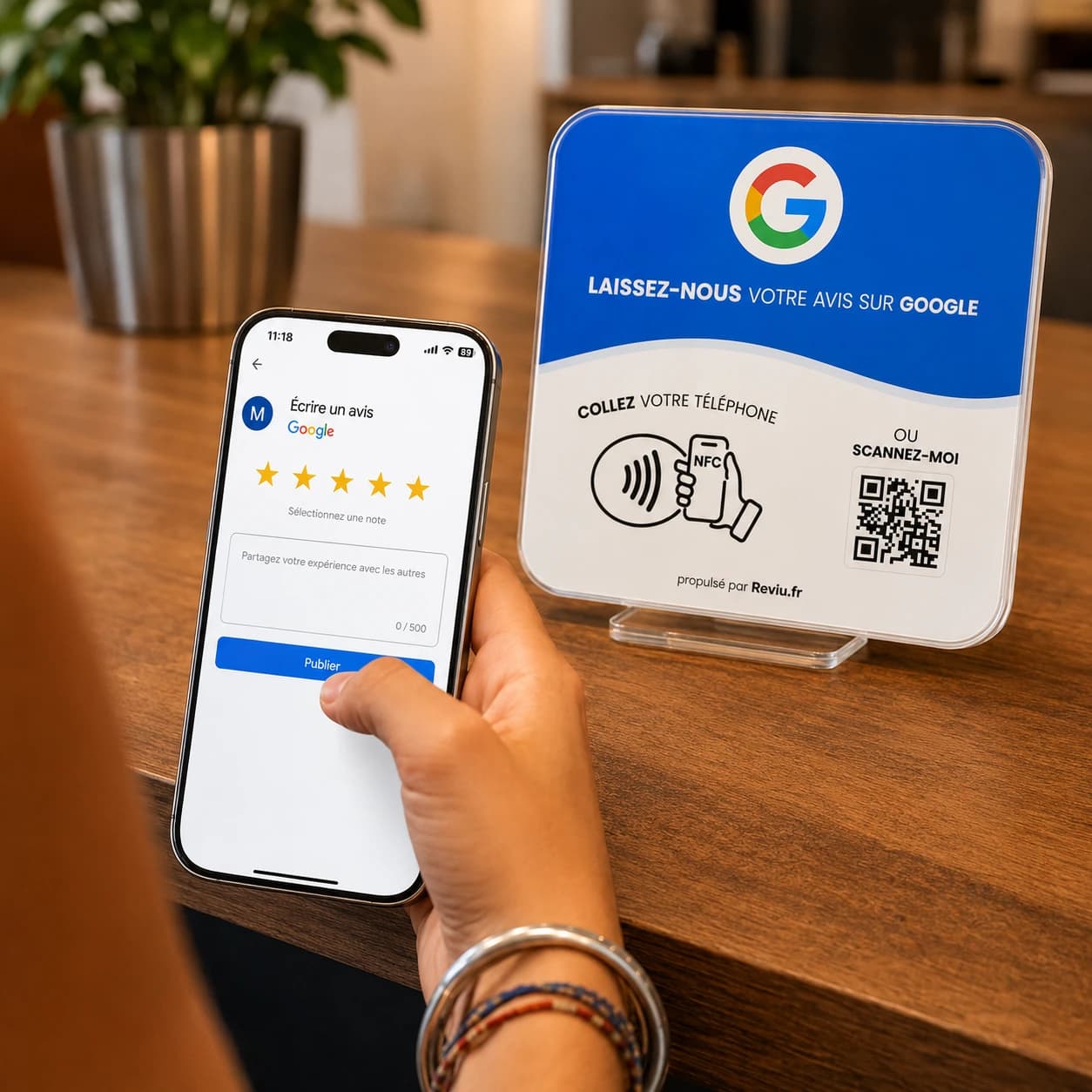 Cliente laissant un avis Google depuis son téléphone devant le présentoir Reviu NFC et QR code, posé sur le comptoir